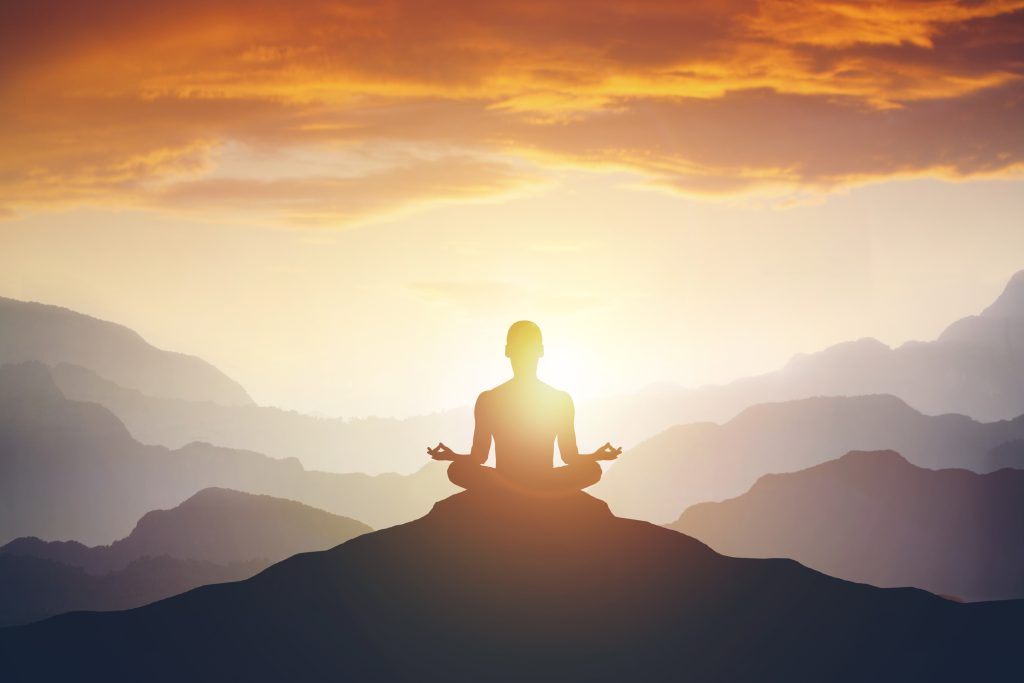 Silhouette of the meditaion man on the mountain. Leadership Concept